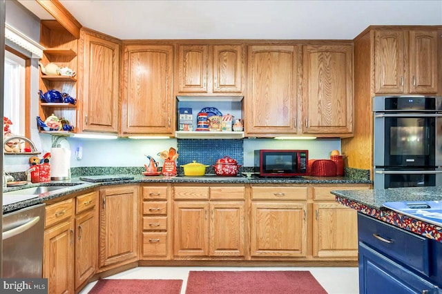 kitchen with sink, dark stone countertops, and stainless steel appliances