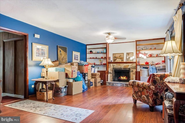 living area featuring wood finished floors and a stone fireplace