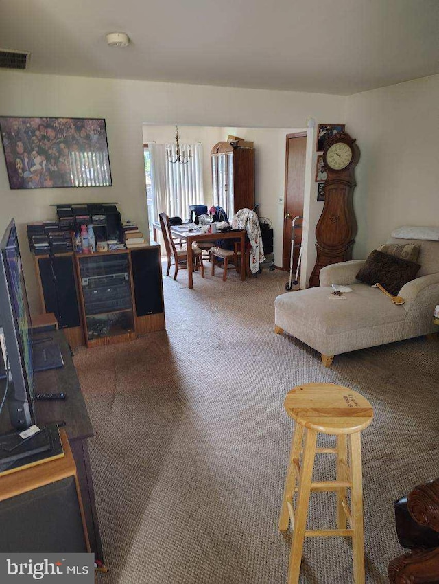 carpeted living room featuring a chandelier