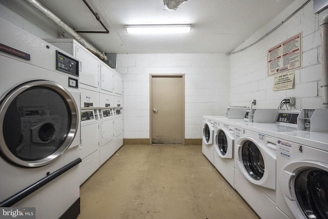 community laundry room featuring washer and dryer, stacked washer and dryer, and concrete block wall