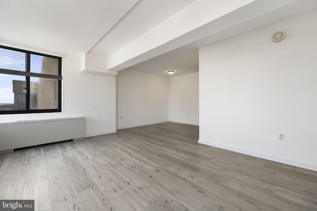 spare room with wood finished floors and baseboards