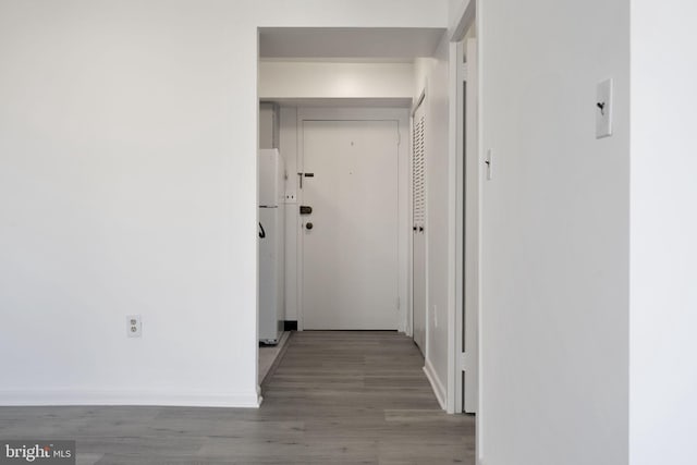 hall featuring baseboards and wood finished floors