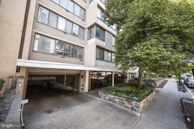 view of building exterior featuring concrete driveway and an attached garage