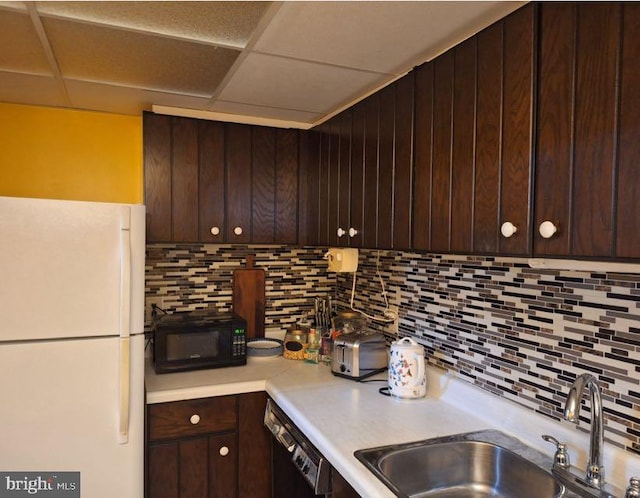 kitchen featuring dark brown cabinets, tasteful backsplash, sink, a paneled ceiling, and black appliances