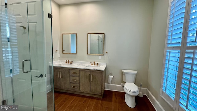 bathroom featuring a healthy amount of sunlight, toilet, hardwood / wood-style flooring, an enclosed shower, and vanity