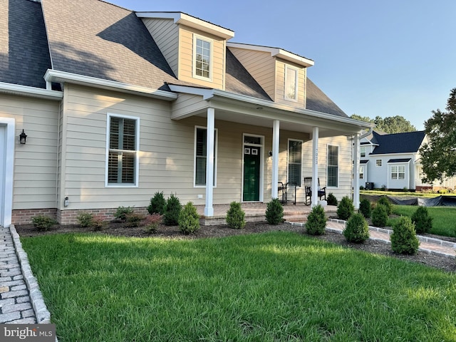 new england style home featuring a front lawn and a porch