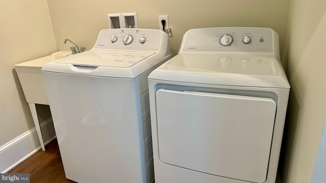 laundry room with washing machine and clothes dryer and dark wood-type flooring