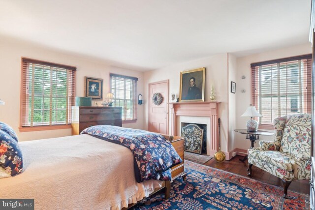 bedroom featuring dark hardwood / wood-style flooring and multiple windows