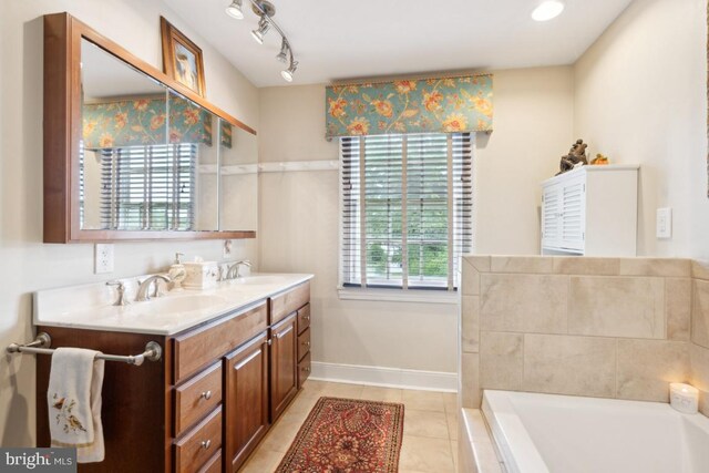 bathroom with a tub to relax in, vanity, tile patterned floors, and plenty of natural light