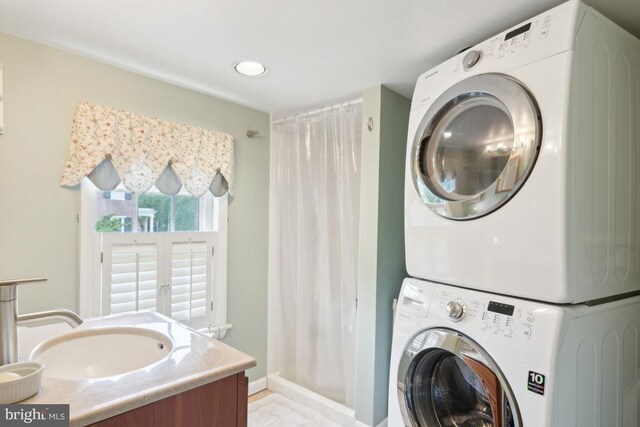 laundry area with stacked washer / dryer and sink