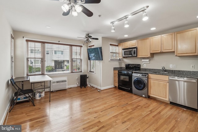 kitchen featuring dark countertops, washer / dryer, stainless steel appliances, and a wall mounted air conditioner