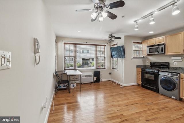 kitchen with light brown cabinetry, washer / clothes dryer, stainless steel microwave, dark countertops, and black gas range oven