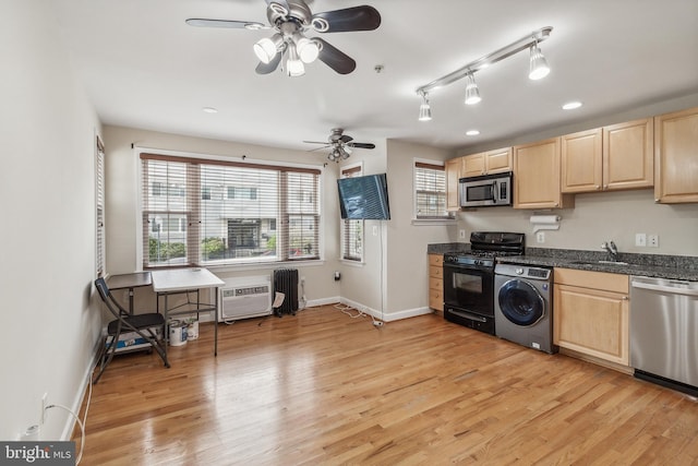 kitchen featuring light brown cabinets, stainless steel appliances, washer / clothes dryer, a sink, and light wood finished floors