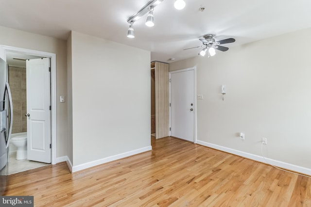 unfurnished room with baseboards, ceiling fan, and light wood finished floors