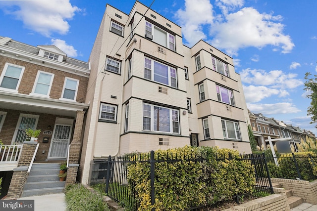 view of building exterior featuring a fenced front yard and a residential view