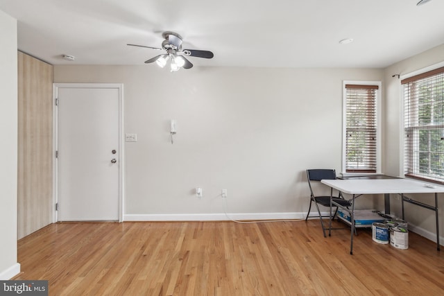 office featuring light wood finished floors, baseboards, and a ceiling fan