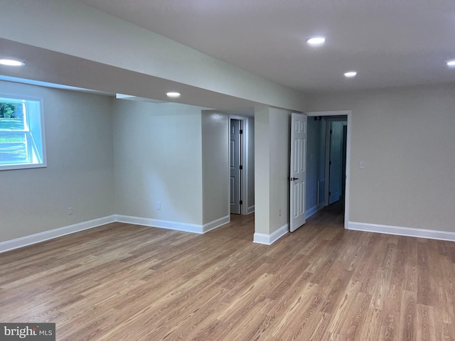 below grade area with light wood finished floors, recessed lighting, and baseboards