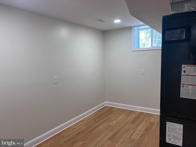 basement featuring visible vents, baseboards, and wood finished floors