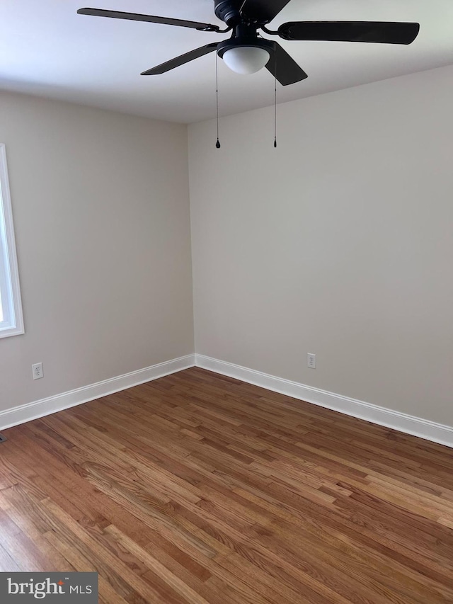 unfurnished room with a ceiling fan, baseboards, and wood finished floors