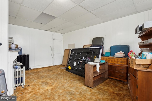 misc room featuring radiator heating unit, carpet flooring, and a paneled ceiling