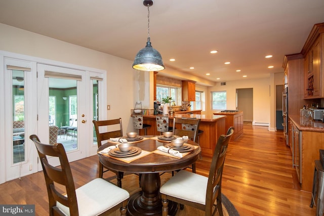 dining room with hardwood / wood-style floors, baseboard heating, and french doors