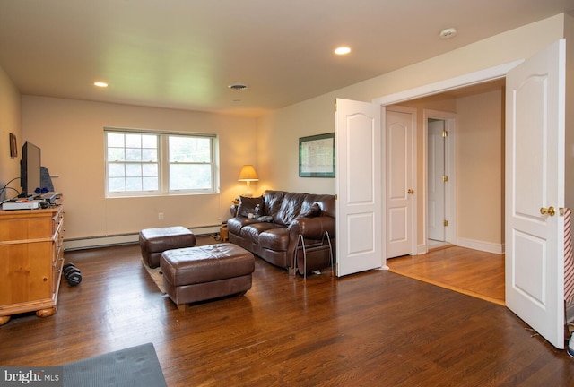 living room featuring a baseboard heating unit and dark hardwood / wood-style floors