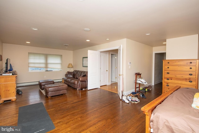 bedroom featuring a baseboard heating unit and hardwood / wood-style floors