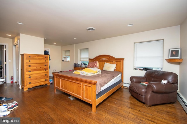 bedroom featuring dark hardwood / wood-style floors and a baseboard heating unit