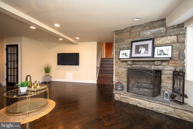 living room with beamed ceiling, a fireplace, and hardwood / wood-style flooring