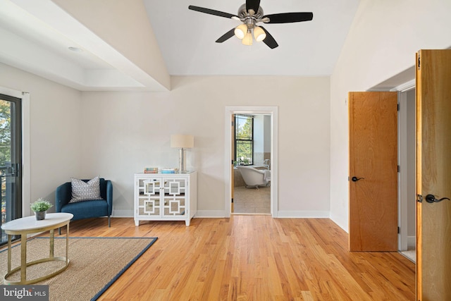 living area featuring light hardwood / wood-style floors, vaulted ceiling, a wealth of natural light, and ceiling fan