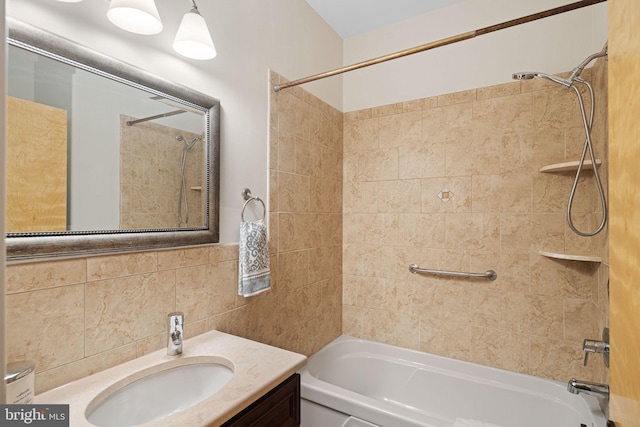 bathroom with tiled shower / bath, vanity, and tile walls