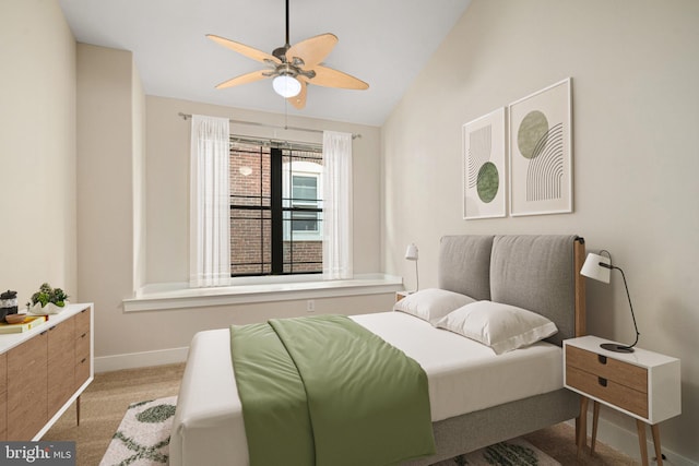 bedroom featuring light colored carpet, vaulted ceiling, and ceiling fan