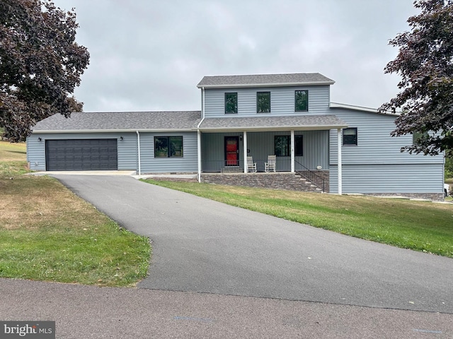 view of front facade featuring a porch, a garage, and a front yard