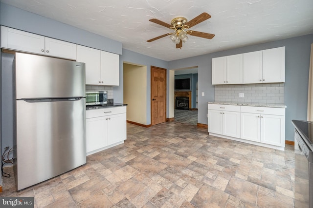 kitchen featuring light tile patterned flooring, appliances with stainless steel finishes, and backsplash