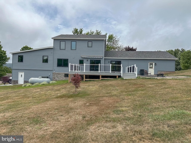 back of house featuring a lawn and a wooden deck