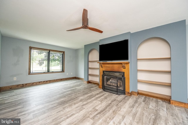 unfurnished living room featuring built in features, light hardwood / wood-style flooring, and ceiling fan