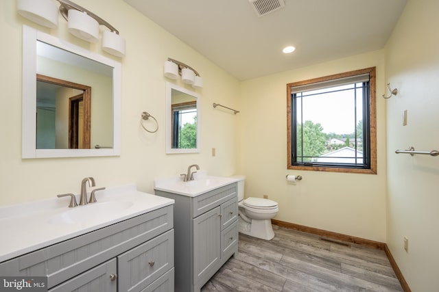 bathroom featuring wood-type flooring, toilet, and vanity