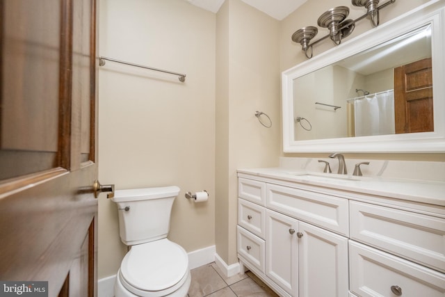 bathroom with toilet, vanity, and tile patterned floors