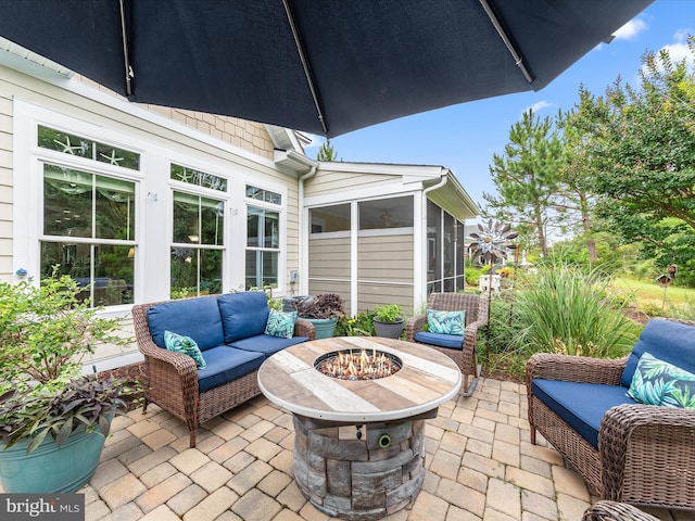 view of patio / terrace featuring a fire pit and a sunroom