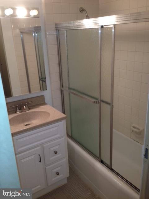 full bathroom featuring combined bath / shower with glass door, vanity, and tile patterned floors