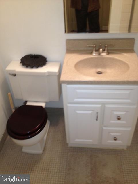 bathroom featuring tile patterned flooring, toilet, and vanity