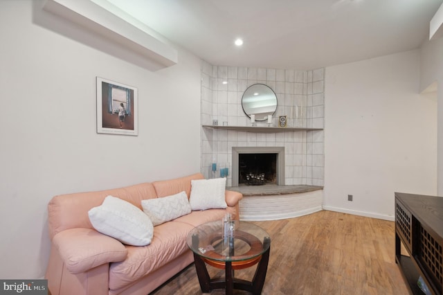 living room featuring a tile fireplace, tile walls, and hardwood / wood-style floors