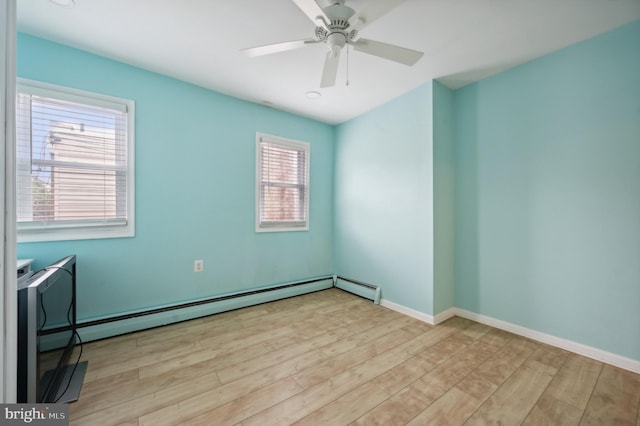 spare room featuring a baseboard heating unit, ceiling fan, and light hardwood / wood-style flooring