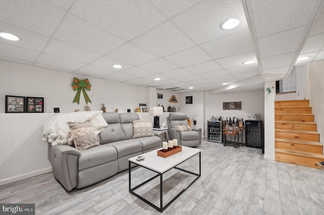 living room featuring a paneled ceiling, hardwood / wood-style floors, and bar area