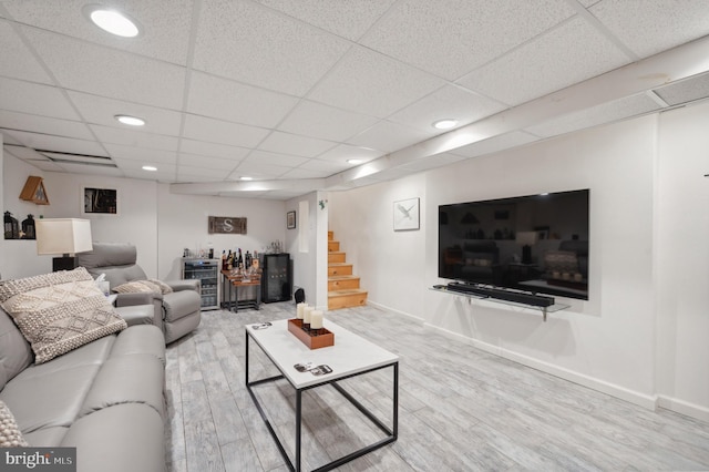 living room featuring light wood-type flooring and a drop ceiling