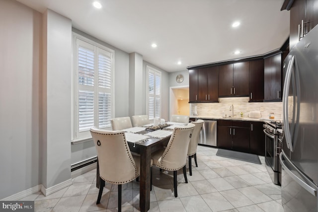 kitchen featuring stainless steel appliances, light tile patterned floors, decorative backsplash, sink, and dark brown cabinetry