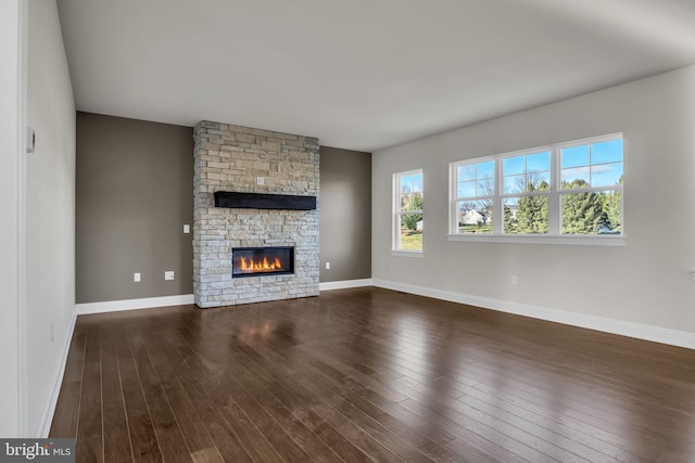 unfurnished living room featuring dark wood-type flooring and a fireplace