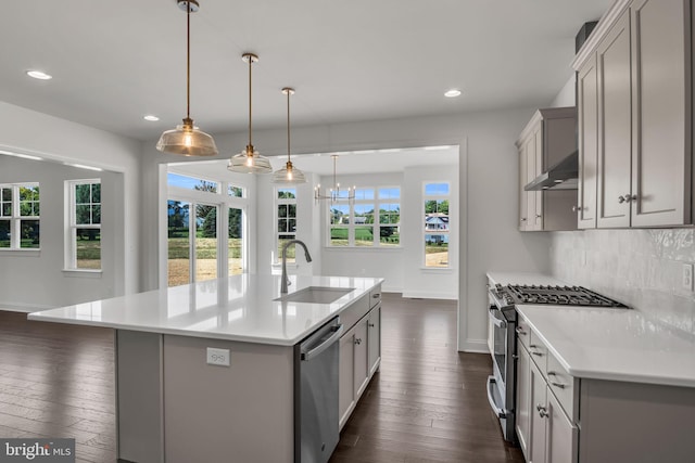 kitchen featuring pendant lighting, an island with sink, stainless steel appliances, and sink