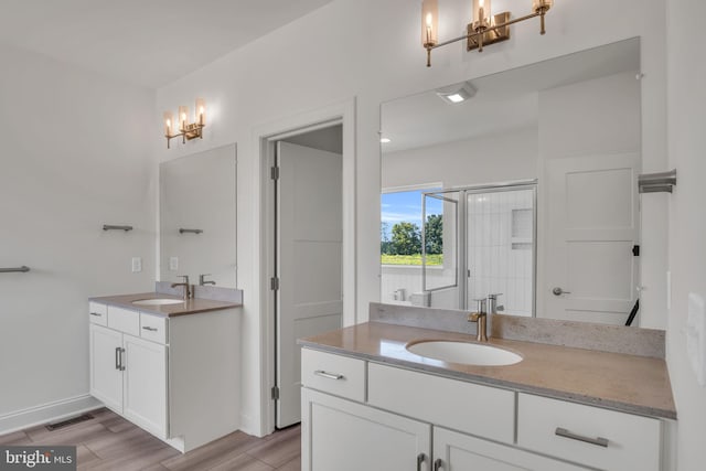 bathroom with walk in shower, vanity, and a chandelier