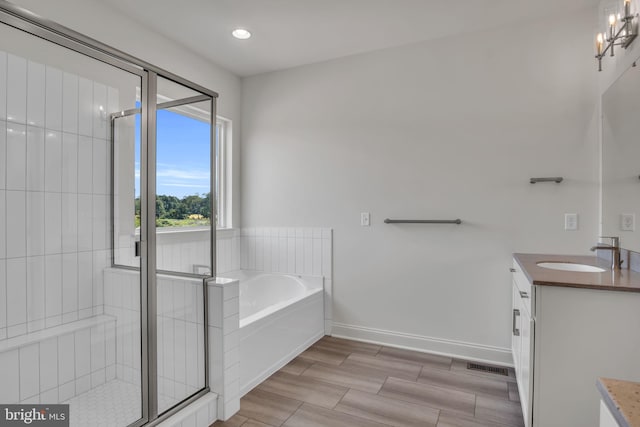 bathroom featuring an inviting chandelier, vanity, and independent shower and bath